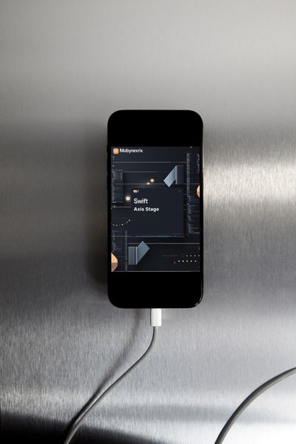 Smartphone displaying a music app on a metallic surface