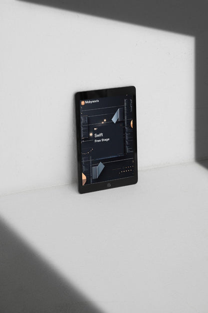 Black tablet on a white surface with a dark screen